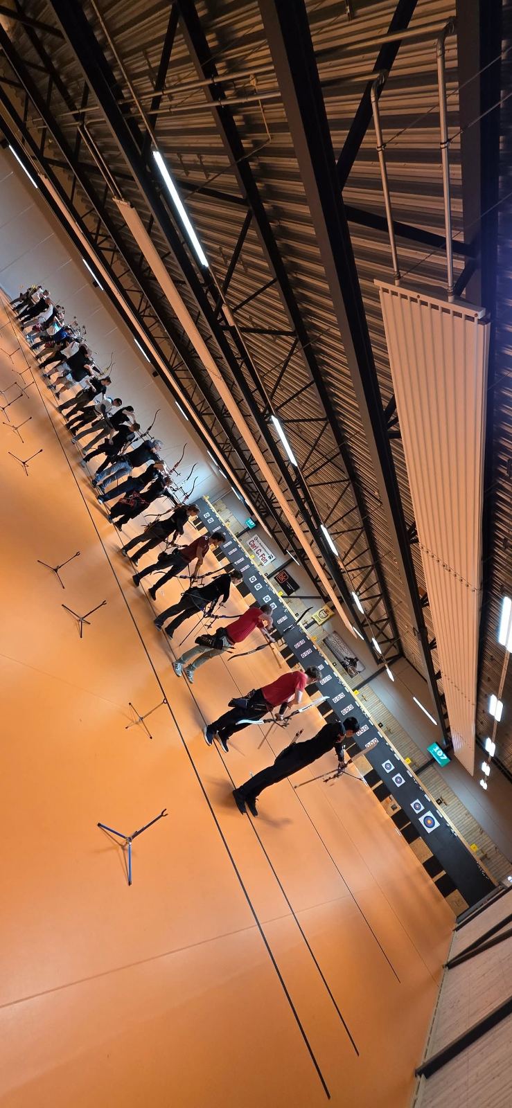 Oversiktsbilde av standplass med skyttere i buehallen